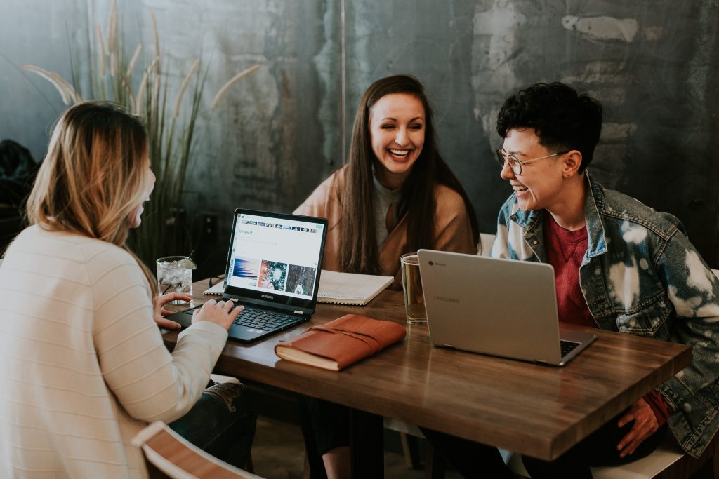 personnes travaillant sur ordinateur et riant ensemble