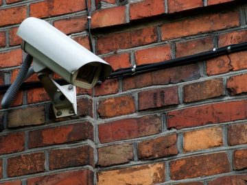 camera de surveillance sur un mur en briques rouges