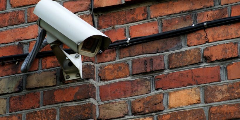 camera de surveillance sur un mur en briques rouges