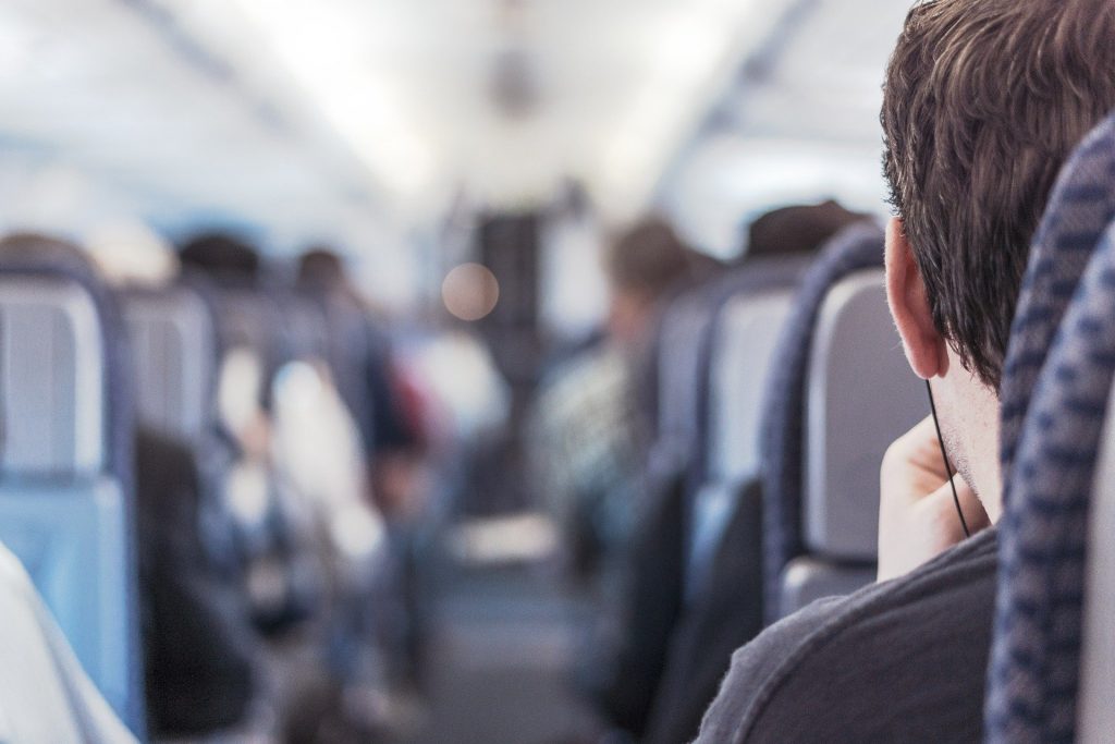 Passager d'un train de dos qui porte des écouteurs