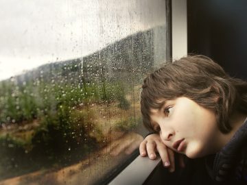 enfant qui s'appuie contre la fenêtre d'un train