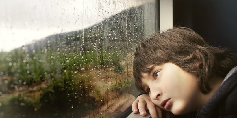 enfant qui s'appuie contre la fenêtre d'un train