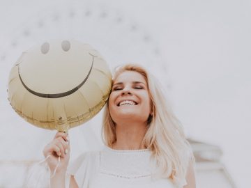 Jeune femme avec une bonne santé bucco-dentaire qui sourit à pleines dents