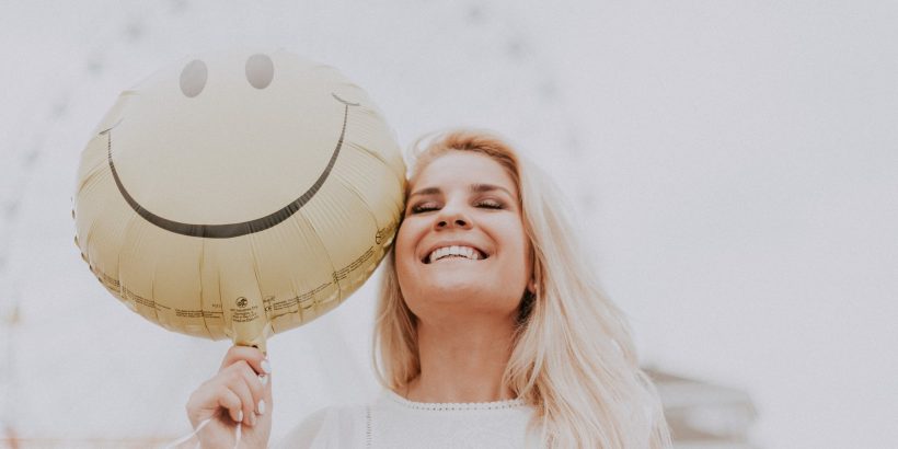 Jeune femme avec une bonne santé bucco-dentaire qui sourit à pleines dents