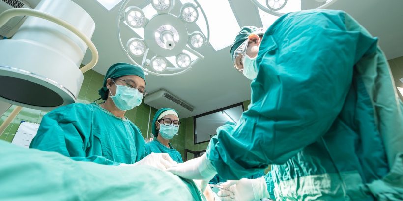 Opération de chirurgie par plusieurs médecins en blouse dans une salle d'opération