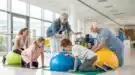 Un petit groupe de patients de tous âges en train de réaliser ensemble des exercices de rééducation sous la supervision d’un thérapeute.